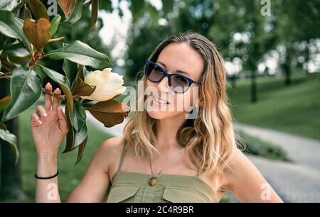 La ragazza sniffs una Magnolia Foto Stock