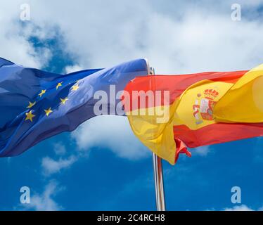 Bandiera spagnola e bandiera dell'Unione europea contro il cielo blu Foto Stock