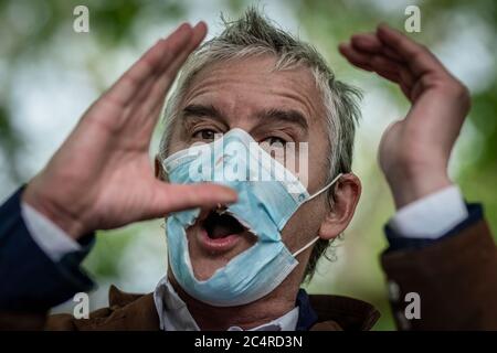 Londra, Regno Unito. 28 Giugno 2020. Heiko Khoo, un oratore veterano al Speakers’ Corner, discute attraverso una maschera facciale gradualmente deteriorante osservando le distanze sociali. Predicazione, dibattiti e sermoni al Speakers’ Corner, l’angolo nord-est di Hyde Park che parla il pubblico. Credit: Guy Corbishley/Alamy Live News Foto Stock