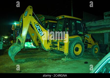 New Delhi, India - 18 agosto 2012: Un escavatore JCB giallo parcheggiato nel lato della città via dopo il lavoro Foto Stock