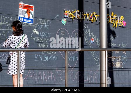 Una donna che si trova accanto a un muro con graffiti.il Tribunale dell’Aia è bloccato di banane dopo un appello del gruppo d’azione ‘STuggle for Freedom’, che risponde al divieto di varie manifestazioni ‘Virus Madness’ che il gruppo voleva tenere. I sostenitori ritengono che i Paesi Bassi siano diventati una repubblica delle banane con questa sentenza. Foto Stock