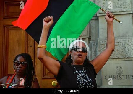 I manifestanti degli 'africani nella diaspora si riuniscono fuori da Christie's a Londra per chiedere il ritorno di manufatti africani 'saccheggiati'. Foto Stock