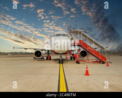 Nan/Thailandia - Febbraio 2020: Un aereo di Air Asia Airlines sta parcheggiando all'Aeroporto di Nan durante l'orario di imbarco. I passeggeri si dirigono a piedi all'aeroporto Foto Stock