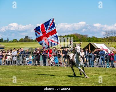 Squadra di stunt equestre Les Amis D'Onno con soldato in uniforme cavallo e bandiera Union Jack, evento bellico, East Fortune, East Lothian, Scozia, Regno Unito Foto Stock