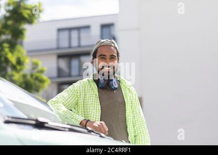 giovane uomo davanti a un'auto con cuffie Foto Stock