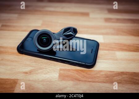 Obiettivo della fotocamera per i telefoni cellulari indossato sul telefono nero Foto Stock