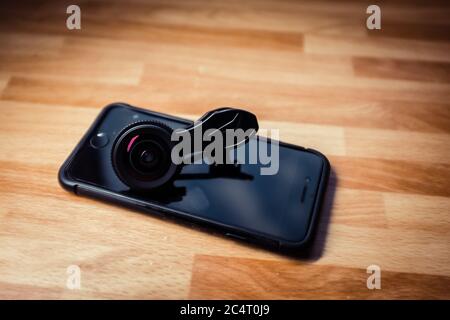 Obiettivo della fotocamera per i telefoni cellulari indossato sul telefono nero Foto Stock