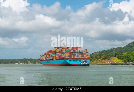 Una grande nave portacontainer con carico che passa attraverso il canale di Panama durante il giorno vicino alle chiuse di Miraflores, Panama. Foto Stock