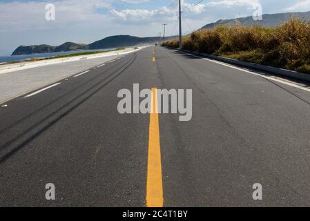 strada semplice con striscia gialla che divide le corsie Foto Stock