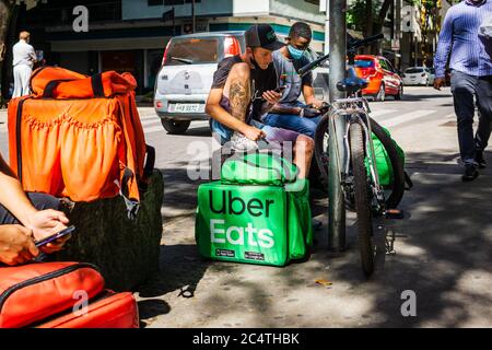 Consegna biciclette autisti per Uber Eats e altri servizi in attesa di ordini di consegna in una strada trafficata a Belo Horizonte, Brasile, durante Covid-19. Foto Stock