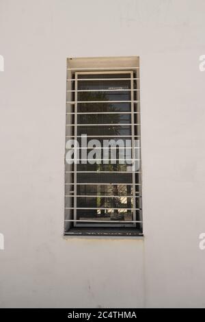Immagine verticale di barre metalliche sulla finestra di a. edificio bianco Foto Stock