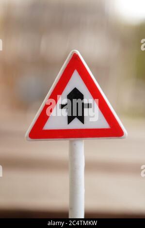 Immagine in primo piano verticale di un segnale di incrocio con un segnale sfocato sfondo Foto Stock