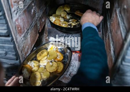 uomo che cucina uova fritte con patate in padella, vista dall'alto, fuoco selettivo. Foto Stock