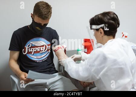 LUBIN, POLONIA - 16 GIUGNO 2020. L'infermiere preleva un campione di sangue dal giocatore di calcio per il test del coronavirus. Foto Stock