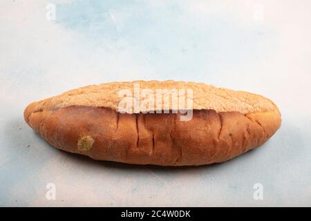 Macrofotografia di muffa verde su un pane raffermo. Superficie di pane ammuffito. Pane guastato con muffa. Fungo ammuffito su pane marcio. Vista dall'alto. Foto Stock