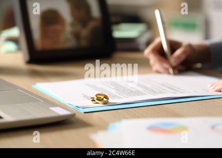 Primo piano di mano imprenditore firma carte divorzio seduta su una scrivania a casa Foto Stock