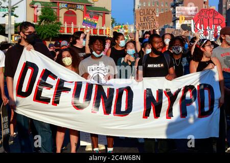 Persone che hanno un banner Defund NYPD in una marcia di protesta verso il Municipio di New York, New York, 25 giugno 2020. Un gruppo di manifestanti marciando lungo Canal Street a Manhattan verso Lower Manhattan. Foto Stock