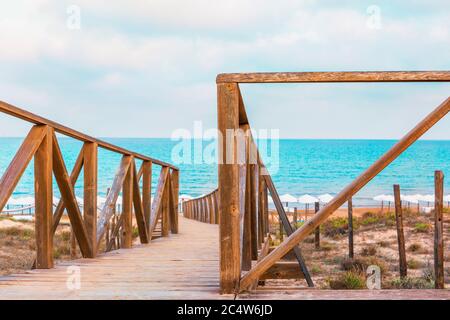 Vista sulla spiaggia di Guardamar ad alicante spagna attraverso l'accesso in legno alla spiaggia Foto Stock