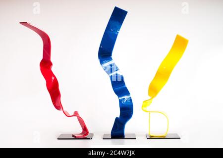 Nastri rossi, blu e gialli che volano nell'aria con uno sfondo bianco Foto Stock