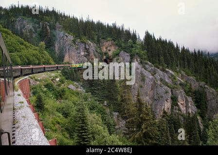 Alaska White Pass e Yukon Route treno ferroviario che viaggia lungo Mountain Route Foto Stock