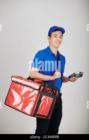 Ritratto di un uomo sorridente che trasporta una grande borsa per il cibo e un terminale di pagamento Foto Stock