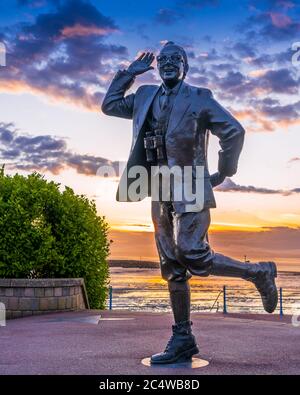 Statua di Eric Morecambe sulla passeggiata di Morecambe al tramonto Foto Stock