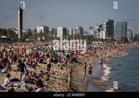 Gli amanti della spiaggia potranno godersi la spiaggia di Bogatell a Barcellona con l'aumento delle temperature estive. Il Consiglio comunale di Barcellona ha progettato un protocollo per il controllo dei volumi di persone, con una capacità massima per ogni spiaggia. Gli esperti avvertono contro misure di sicurezza rilassanti poiché la pandemia potrebbe portare a una seconda ondata. Foto Stock
