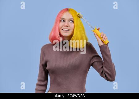 Bella ragazza tinge i capelli con rullo da costruzione Foto Stock