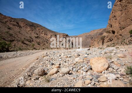 Strada ghiaia e paesaggio nel Wadi Arbiyeen di Oman Foto Stock