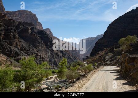 Strada ghiaiosa e paesaggio montano nel Wadi Arbiyeen di Oman Foto Stock