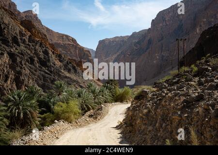 Strada ghiaiosa e paesaggio montano nel Wadi Arbiyeen di Oman Foto Stock