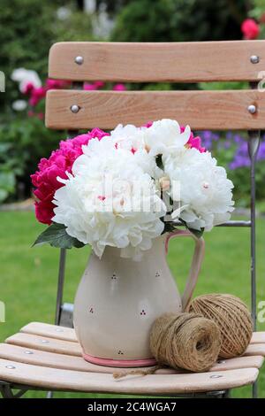 bouquet di peonie bianche e rosa in vaso rustico Foto Stock