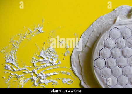 cottura gnocchi di carne nella forma di approvvigionamento su un tavolo da cucina giallo, vista dall'alto della struttura del cibo. Foto Stock