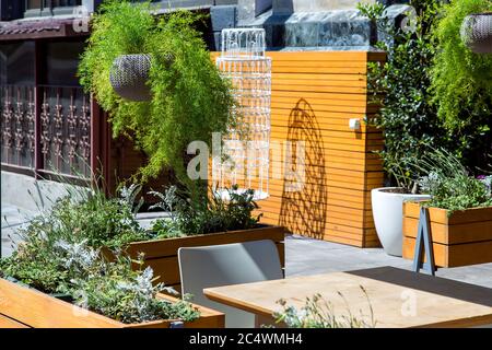 Piante nei vasi di fiori presso il luogo del caffè estivo, vasi di fiori appesi e installati sul marciapiede. Foto Stock