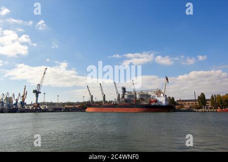 Big Grain terminal al porto. Trasporto alla rinfusa di cereali dal trasporto su strada alla nave. Caricamento di prodotti di grano sulla nave da grandi elevatori alla bandella Foto Stock