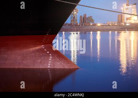 Contrassegni di pescaggio su una nave - numeri di galleggiamento sulla prua e poppa di una nave al porto marittimo di notte Foto Stock