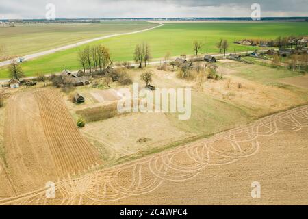 Bielorussia. Veduta aerea del Villaggio Belarusiano. Splendido paesaggio rurale in vista dall'alto. Inizio della stagione di primavera agricola. Tracce su arato Foto Stock