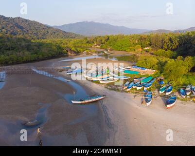 La splendida natura dello stato di Goa vicino alla spiaggia di Palole al tramonto e barche da pesca. India. Vista drone. Foto Stock