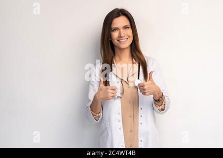 Medico amichevole con i pollici in su - isolato su bianco. Foto Stock