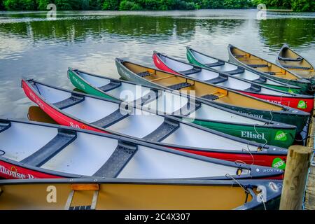 Canoe e kayak colorati ormeggiati e legati a un pontile di legno in Salhouse Broad nel Norfolk Broads Foto Stock