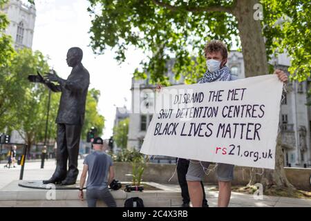 Un giovane ha un cartello di protesta durante una dimostrazione di Black Lives Matter, Parliament Square, Londra, 21 giugno 2020 Foto Stock