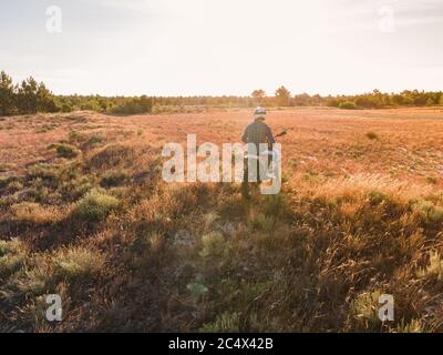 Enduro Racer seduto su una motocicletta e guardare il tramonto. Foto Stock