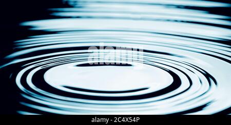 Goccia d'acqua che cade in acqua facendo un perfetto cerchio concentrico. Foto Stock