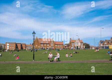 Hunstanton Green, vista in estate di persone che si rilassano sul Green nella località costiera nord Norfolk di Hunstanton, Inghilterra, Regno Unito. Foto Stock