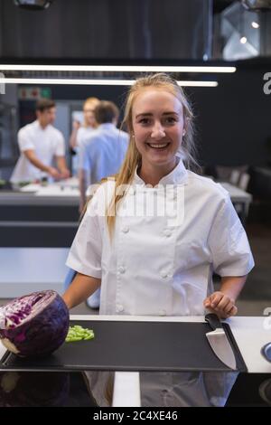 Ritratto di chef femmina sorridente in cucina ristorante Foto Stock