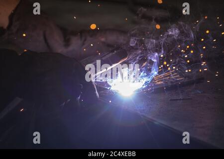 Primo piano di una saldatura in fabbrica maschile Foto Stock