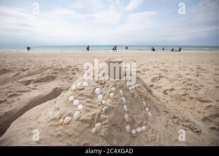 11 giugno 2020, Schleswig-Holstein, Westerland/Sylt: Un piccolo castello di sabbia con l'iscrizione 'Silt' fatto di conchiglie sulla spiaggia di Westerland su Sylt. Foto: Christian Charisius/dpa Foto Stock