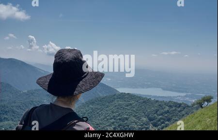 Donna o ragazza che guarda il paesaggio del Lago di Como da un sentiero alpino Foto Stock