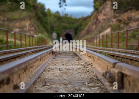 Vista prospettica dei binari ferroviari che si trovano sopra il fiume Teatinos, negli altipiani delle montagne andine della Colombia centrale. Foto Stock