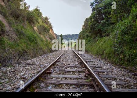 Vista prospettica dei binari ferroviari che si trovano sopra il fiume Teatinos, negli altipiani delle montagne andine della Colombia centrale. Foto Stock